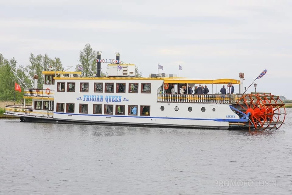 De Frisian Queen raderboot tijdens een vaartocht op de Friese meren met gasten aan boord